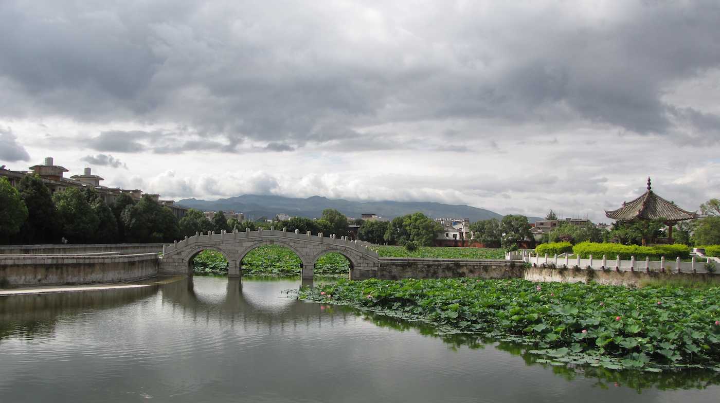 view of bridge over water and mountains in the background